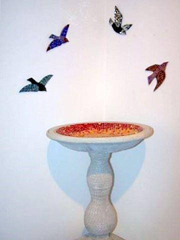 Cement birdbath mosaiced in stained glass and mirror.